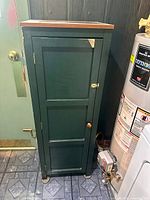 Full front view of green cupboard beside appliances