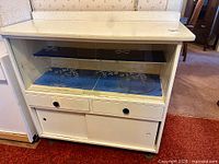 Full view of white sideboard showing glass doors, drawers, melamine top, casters