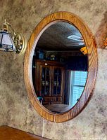 Front view of oval oak wall mirror