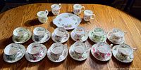 Entire set laid out showing cups, saucers, platter, mugs