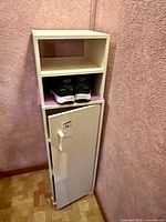 Full view of white shoe cupboard showing top open shelves and lower cabinet door closed