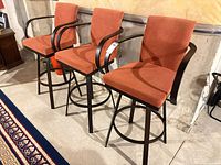 Front angled view showing all three stools, frames, upholstery and arms