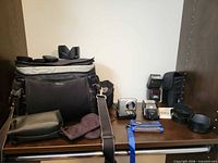 Group shot showing camera bag, Canon camera, flashes, lens hoods, pouches, Think Tank holder