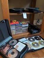 Overall view showing stack of jewel-case CDs and multiple black zippered binders