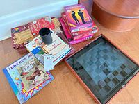 Stack of boxed games, books, glass multi-game board