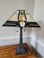 Full view of lamp showing stained glass shade, resin base and twin pulls