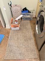 Overall view of rug, hamper, clear tote, baskets