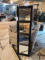 Front view showing four beveled mirror squares in dark wood frame