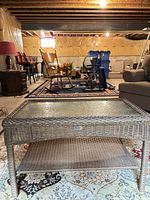 Full view of rattan coffee table with glass top and lower shelf