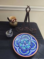 Group shot of easel, pitcher, plate, mortar and pestle