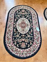 Full view of oval rug on hardwood floor