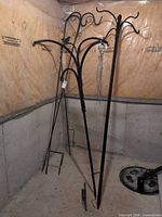 Two 4-arm basket towers and shepherd hooks standing against wall