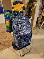 Full view of folding aluminum shopping cart with paisley canvas bag and additional pineapple tote