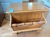 Front view of light wood side table showing magazine rack and top