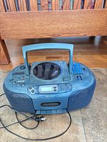 Front view of Sony boombox showing speakers, cassette deck, controls and power cord