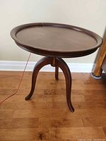 Full view of Bombay round pie-crust table on floor