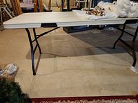 Full view of unfolded 6 ft plastic table showing top and folding legs