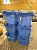 Stack of six blue Rubbermaid totes front view