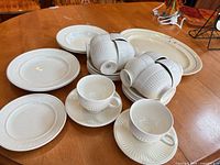 Group view of all off-white Wedgwood dishes and Johnson Bros platter on table