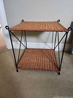 Full view of two-tier wicker side table showing metal frame and wicker shelves