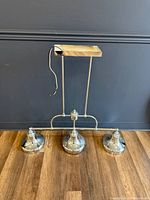 Front view of chrome 3-light pendant fixture on floor