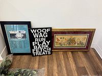 Three wall art pieces leaning against wall