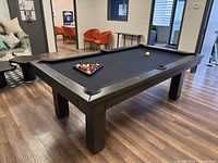 Angled view of pool table with accessories on black cloth