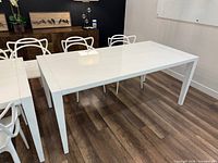 Full view of white glossy dining table, chairs adjacent not included