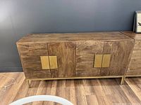Front view of wood sideboard with brass pulls and base