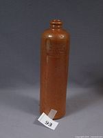 Full view of brown stoneware bottle standing upright