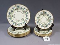 Stacks of large and small plates with two plates on stands displaying pattern