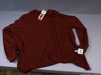 Full view of burgundy long-sleeve waffle-knit henley shirt with tags
