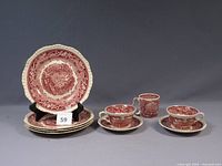 Stack of five dinner plates on stand with saucer, teacups, mug