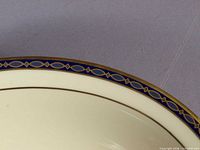 Close view of cobalt and gold patterned rim on cream ground