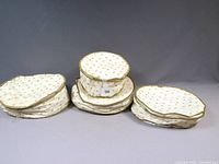 Group view of six cream and gold padded china storage cases