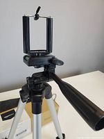 Tripod assembled with phone clamp mount, showing pan handle and bubble level