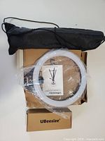 Ring light kit components in box: ring light, tripod, phone mount, bag, manual