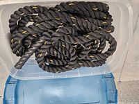 Black 3-strand battle rope coiled in clear tote