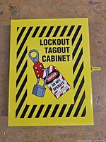 Front view of yellow lockout tagout cabinet showing graphics and latch