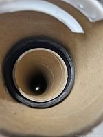 View into cardboard tube showing rolled black fabric and inner support core