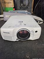 Front view of Panasonic projector showing lens and branding