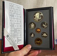 Closed case opened showing seven proof coins in fitted insert