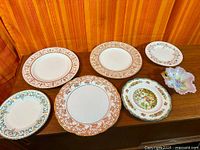 Group of seven assorted porcelain plates and dish on tabletop