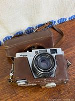 Front view of Fujica 35-ML camera inside leather case with strap