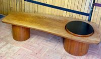 Three-quarter view of teak coffee table showing top, inset and both pedestal bases