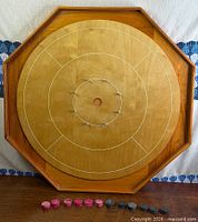 Full view of octagonal crokinole board with playing discs lined at bottom edge