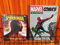 Both books displayed on rack: Spider-Man Ultimate Guide and Marvel Comics Poster Collection