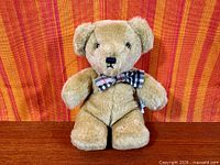 Full front view of Burberry teddy bear showing fur, bow tie, facial features