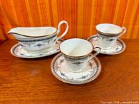 gravy boat on underplate with two cup and saucer sets