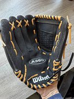 Open palm view showing Wilson logo, A360 model marking, pocket web, and lacing condition